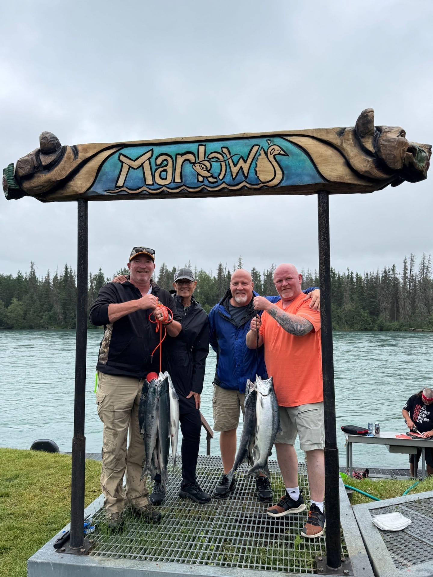 Group of friends with salmon under the Marlow's sign