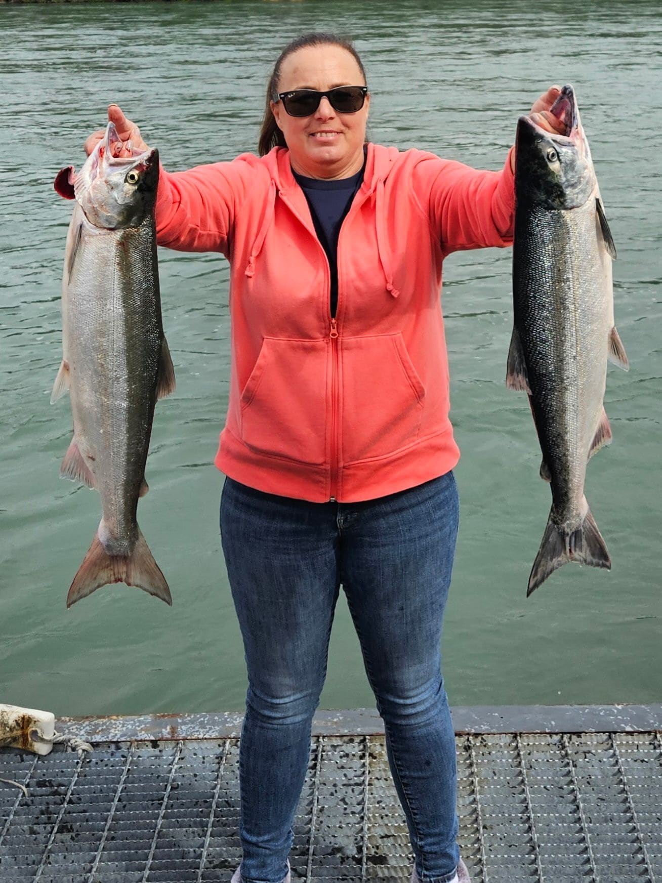 Angler showing off two salmon on the dock